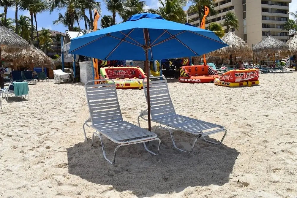 Aruba Beach Umbrella booking set up on the sand: one beach umbrella and two reclining chairs